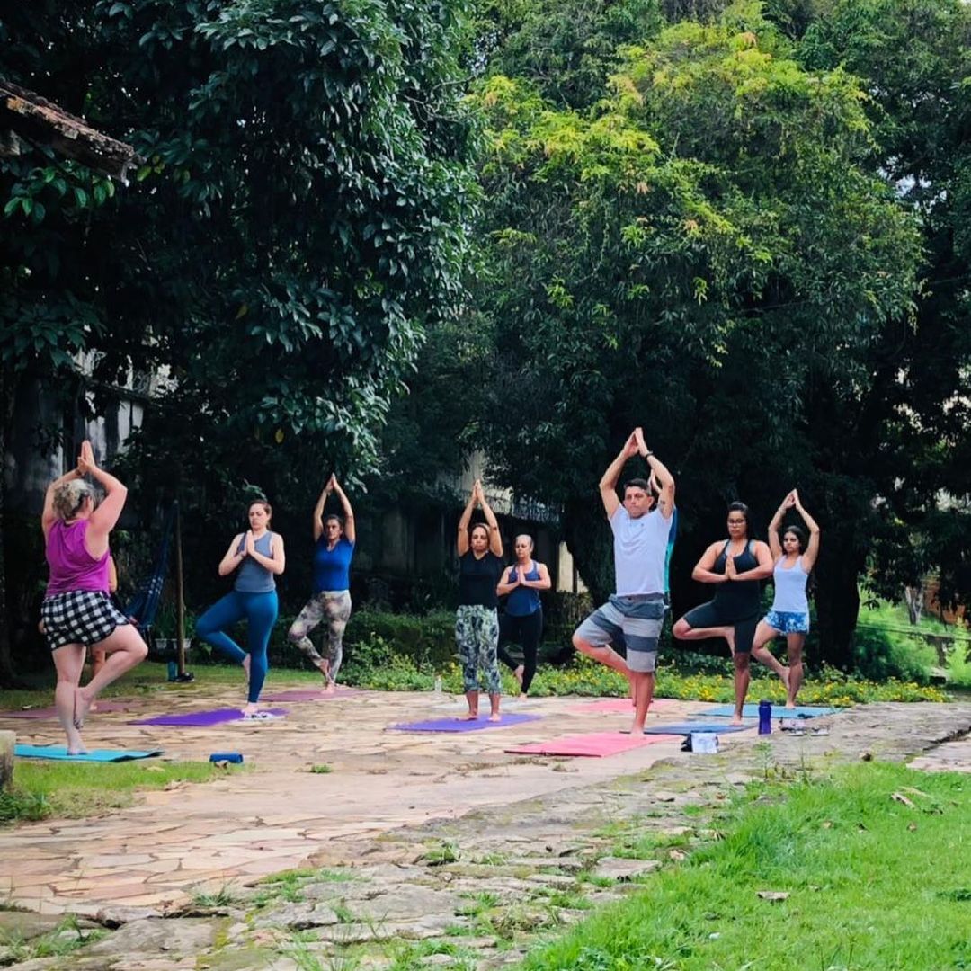 Vemos, em uma área verde com um pequeno campo aberto, a prática de yoga na Casa do Equilíbrio, mais um negócio participante do Projeto Horizonte (Imagem: Reprodução Instagram A Casa do Equilíbrio).