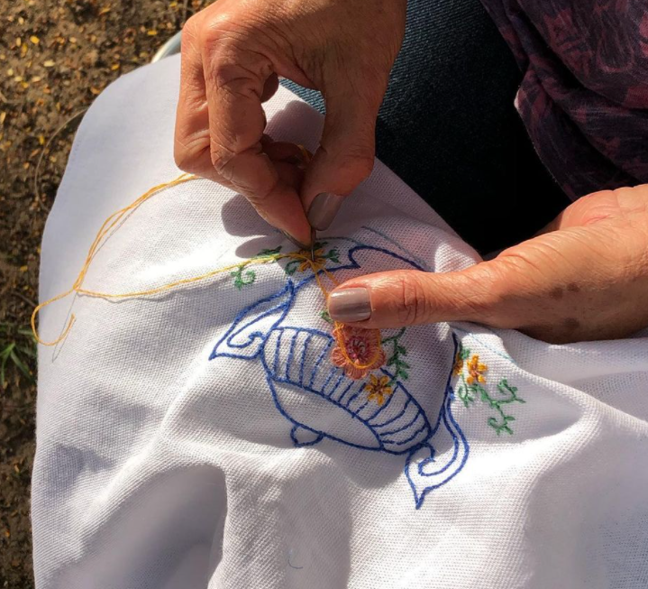 Vemos as mãos de uma mulher fazendo bordado. Imagem retirada do Instagram do Memória de Agulha, negócio que faz parte do Projeto Horizonte.